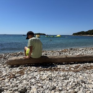 Alex nach dem Schwimmen im Meer vertieft ins Handy