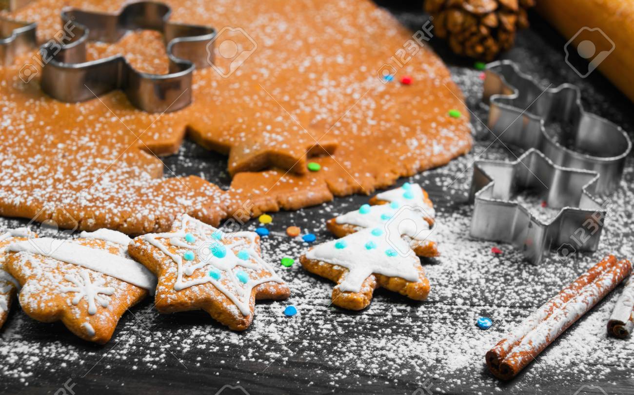 65783818-kochen-weihnachtspl%C3%A4tzchen-lebkuchen-auf-einem-dunklen-braunen-hintergrund-lebkuchenteig-formulare-f%C3%BCr-die-.jpg